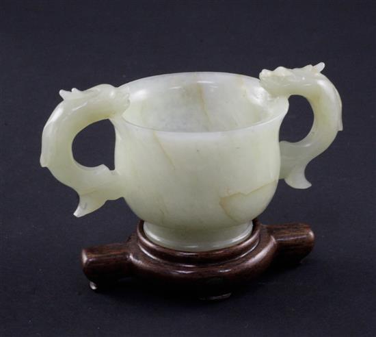 A Chinese bowenite jade two handled cup, Ming dynasty or later, 10.8cm., wood stand